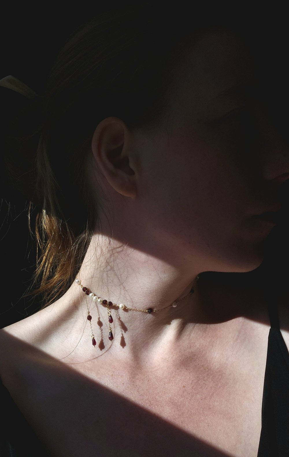 girl posing wearing red necklace
